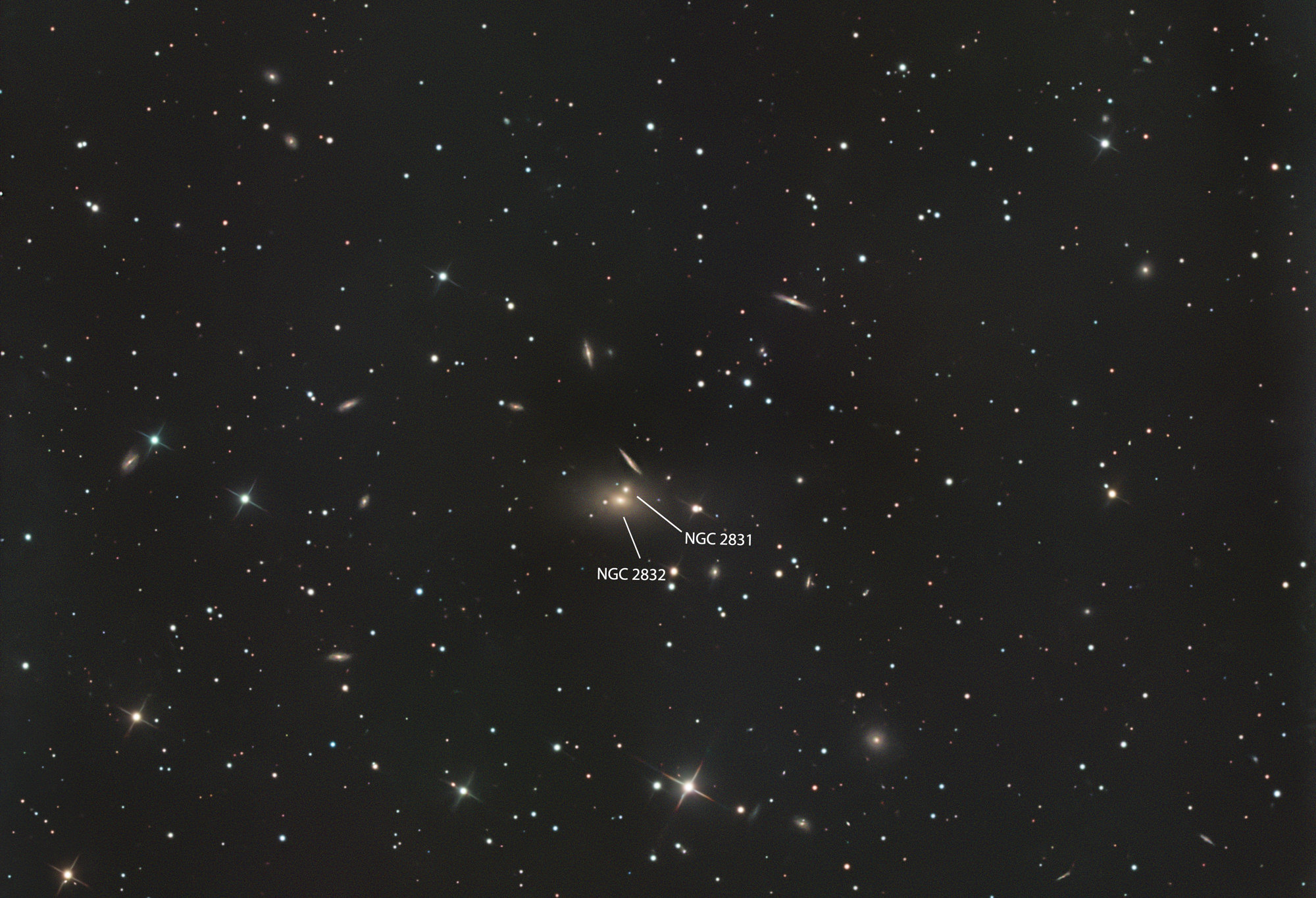 Abell 779 is a galaxy cluster in the constellation Lynx and contains several important galaxies, including NGC 2832. Overall, the galaxies in the cluster are tiny. The largest and brightest is NGC 2832 in the center of the image, a type cD galaxy. It appears to interact tidally with the galaxy NGC 2831, located 25 arcseconds away, and lies in the same halo as NGC 2832.